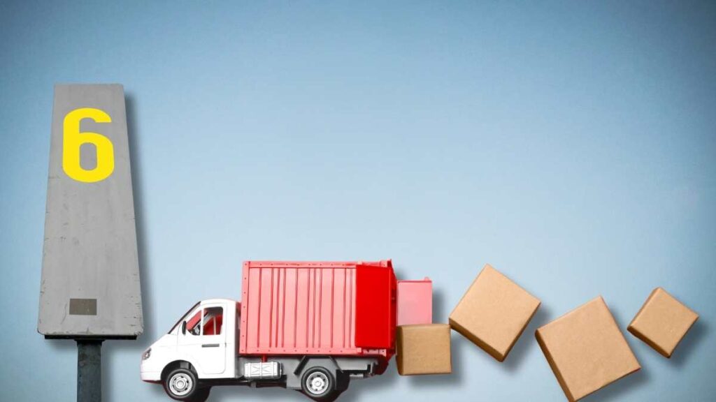 Delivery truck unloading boxes beside a number six marker
