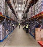 Warehouse inventory storage with workers managing stock and inventory records.