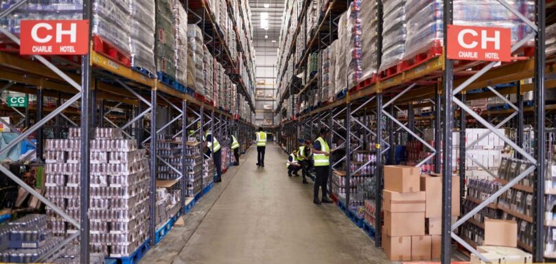 Is Your Inventory Management System Slowing Down Business Growth? 9 Warehouse inventory storage with workers managing stock and inventory records.