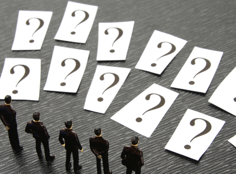 5 honest reason - feature image Miniature business figures standing before multiple question cards, representing decision-making