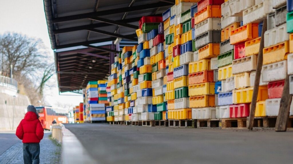 Rows of colour-coded storage crates stacked in a warehouse storage area